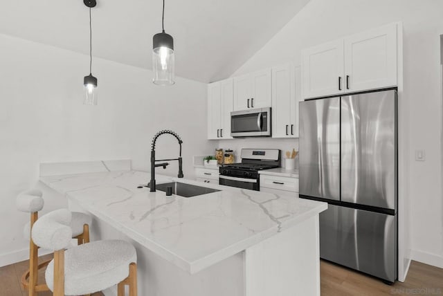 kitchen with white cabinets, kitchen peninsula, appliances with stainless steel finishes, and sink