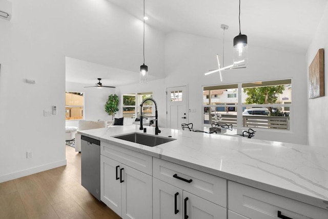 kitchen featuring decorative light fixtures, sink, white cabinets, and stainless steel dishwasher