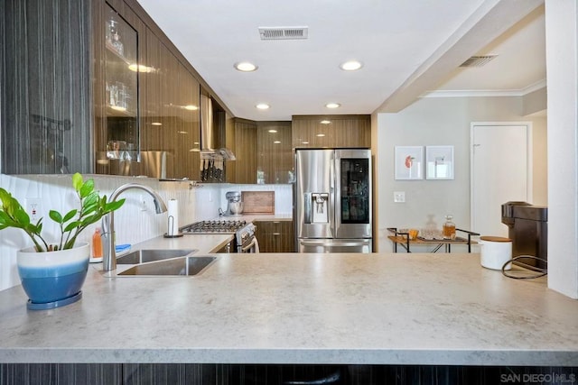 kitchen with tasteful backsplash, sink, appliances with stainless steel finishes, ornamental molding, and wall chimney exhaust hood