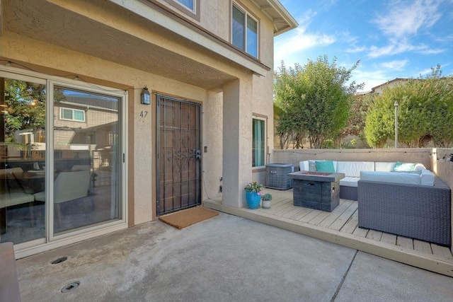 deck with an outdoor living space with a fire pit and a patio