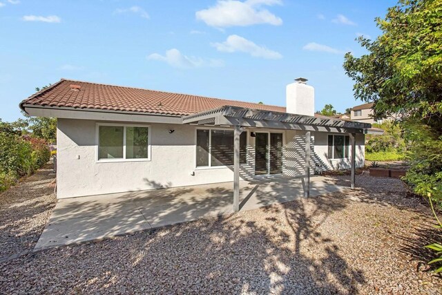 rear view of property with a patio area and a pergola