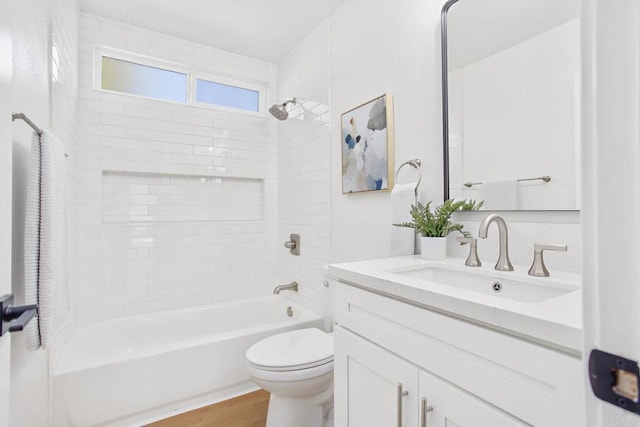 full bathroom with hardwood / wood-style floors, tiled shower / bath combo, vanity, and toilet