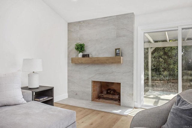 bedroom featuring access to exterior, a high end fireplace, and hardwood / wood-style flooring