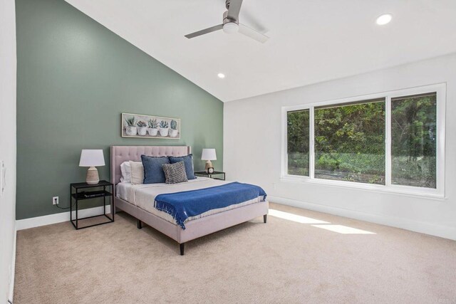 carpeted bedroom with vaulted ceiling, ceiling fan, and multiple windows