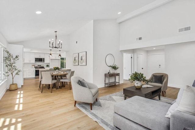 living room with high vaulted ceiling, light wood-type flooring, and a chandelier