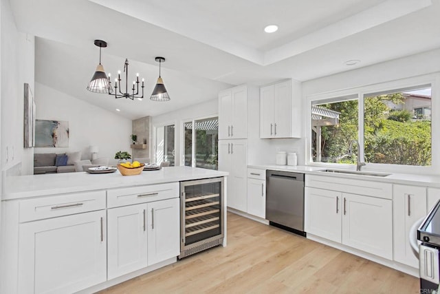 kitchen with white cabinetry, decorative light fixtures, beverage cooler, stainless steel dishwasher, and sink