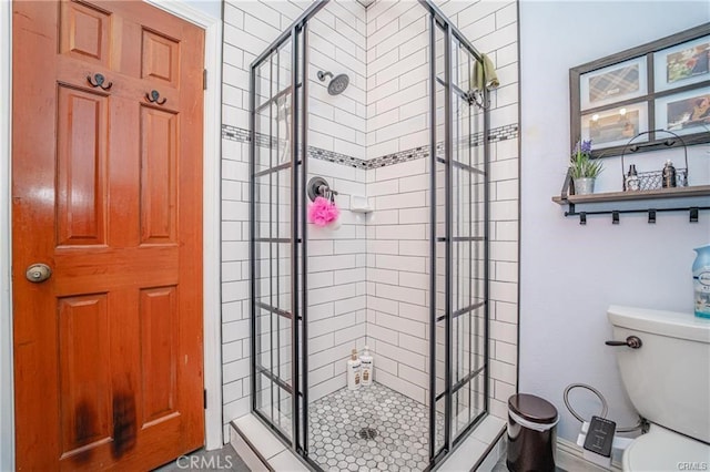 bathroom featuring a shower stall and toilet