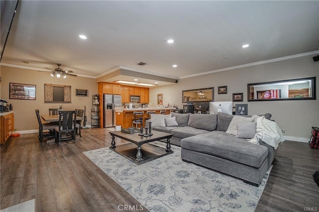 living room with recessed lighting, dark wood-style flooring, visible vents, baseboards, and crown molding