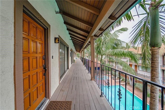 wooden deck with a community pool