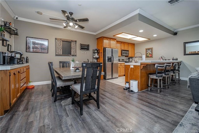 dining area featuring wood finished floors and crown molding