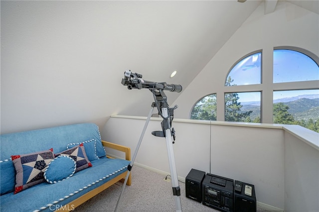 interior space featuring vaulted ceiling, a mountain view, and carpet flooring