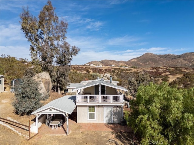 back of property featuring a mountain view and a carport