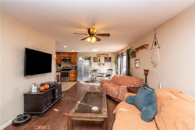 living room featuring ceiling fan and dark hardwood / wood-style floors