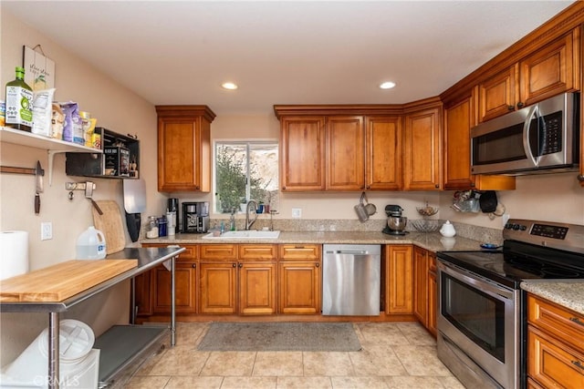 kitchen featuring sink, light stone counters, and stainless steel appliances