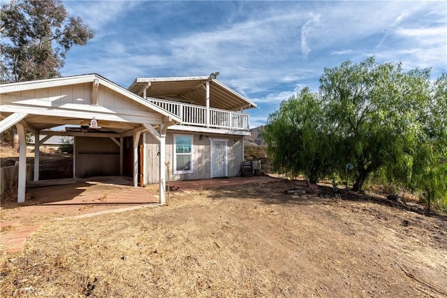 back of property featuring a carport and a balcony