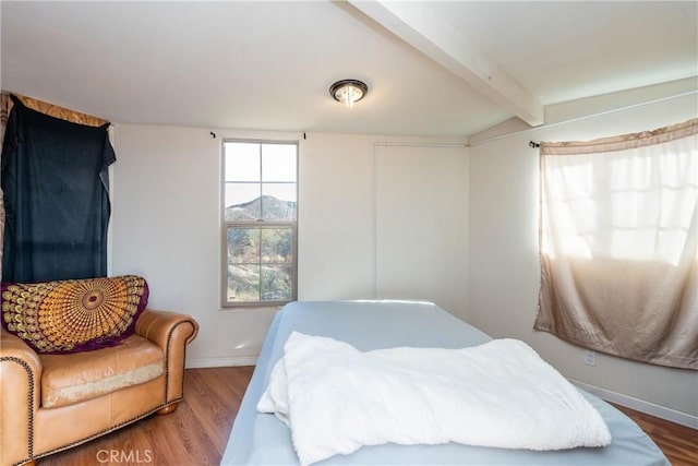 bedroom featuring wood-type flooring and beamed ceiling