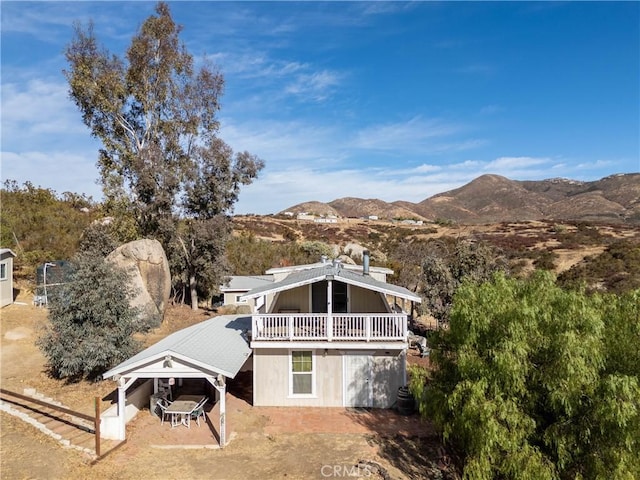 back of house featuring a mountain view and a balcony