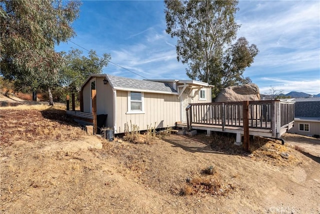 view of side of property with a deck with mountain view