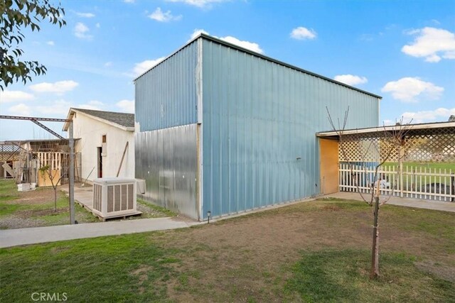 view of outdoor structure with central AC and a lawn