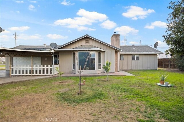 rear view of house featuring a yard and a garage