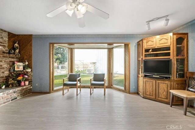 living area featuring ceiling fan, rail lighting, and light hardwood / wood-style floors