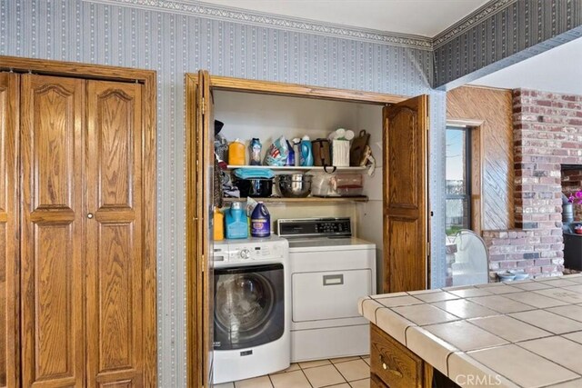 laundry area with light tile patterned floors and washer and dryer