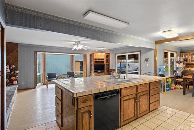 kitchen with ceiling fan, tile counters, black dishwasher, crown molding, and sink