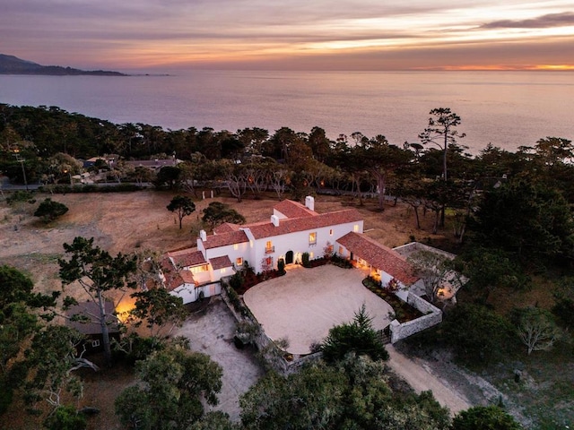 aerial view at dusk featuring a water view