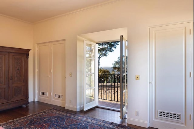 foyer entrance with ornamental molding and dark hardwood / wood-style flooring