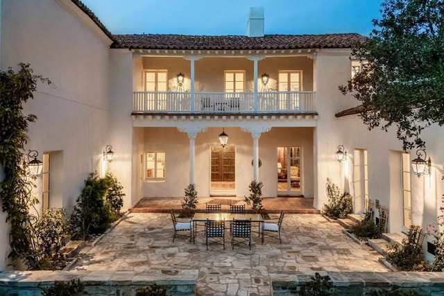 rear view of property featuring a balcony and a patio