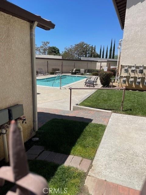 view of pool featuring a lawn and a patio