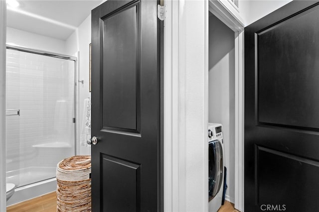 laundry area with washer / dryer and light hardwood / wood-style flooring