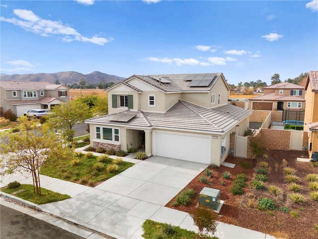 view of front of property featuring a mountain view, solar panels, and a garage