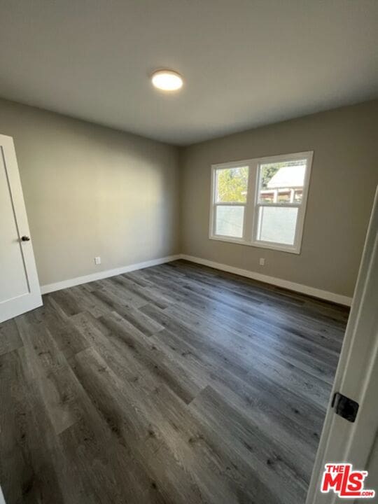 unfurnished room featuring dark hardwood / wood-style floors