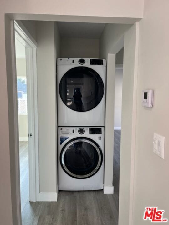 washroom featuring stacked washer and dryer and dark hardwood / wood-style floors