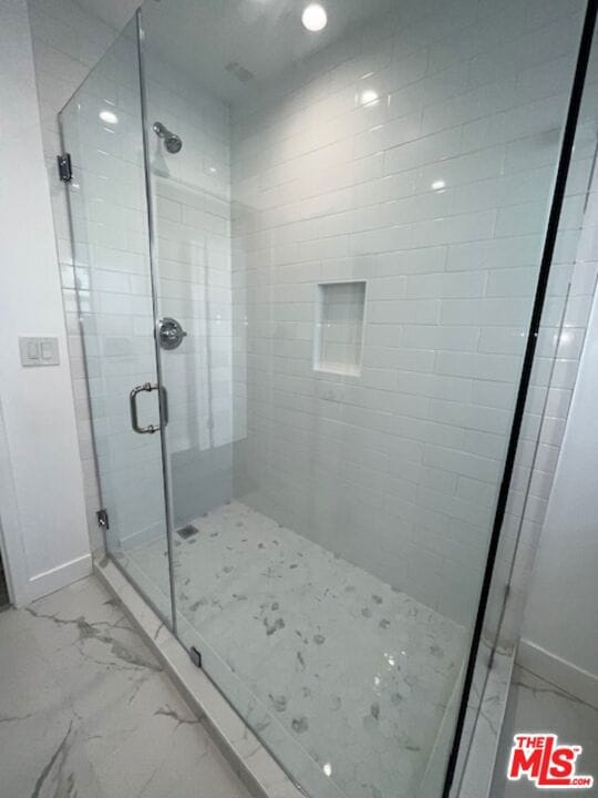 bathroom featuring a shower with door