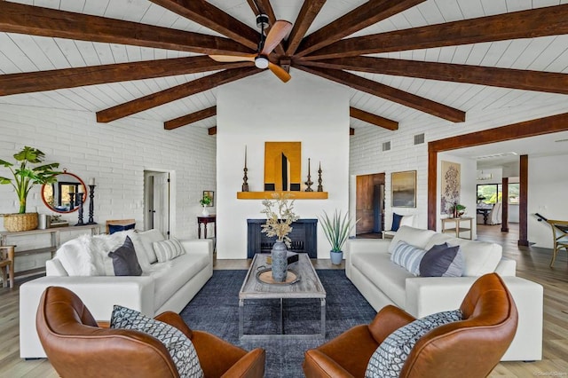 living room featuring vaulted ceiling with beams, ceiling fan, light hardwood / wood-style floors, and brick wall