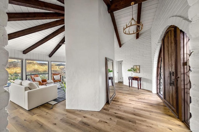 foyer with beam ceiling, light hardwood / wood-style flooring, and high vaulted ceiling