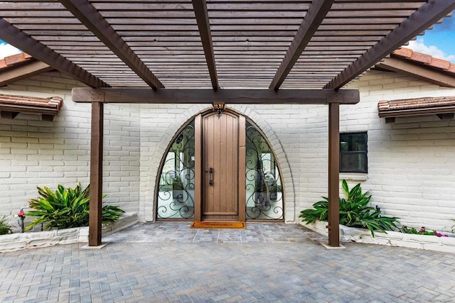 entrance to property featuring a pergola and a patio