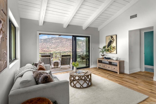 living room featuring hardwood / wood-style floors, a mountain view, and lofted ceiling with beams