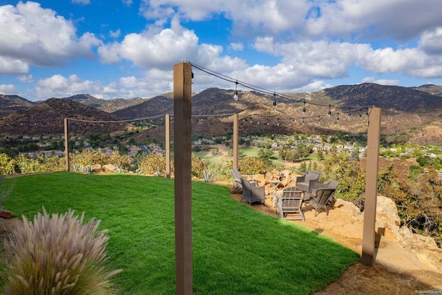 view of yard featuring a mountain view and an outdoor fire pit