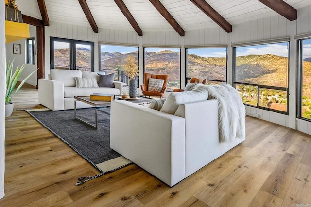 living room featuring a mountain view, lofted ceiling with beams, light hardwood / wood-style floors, and wooden ceiling