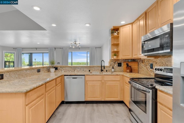 kitchen featuring light brown cabinetry, sink, a wealth of natural light, and appliances with stainless steel finishes