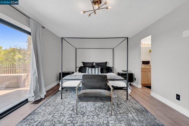 bedroom featuring ensuite bathroom, wood-type flooring, and a chandelier