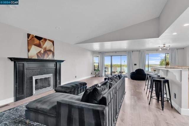 living room with light hardwood / wood-style floors and vaulted ceiling