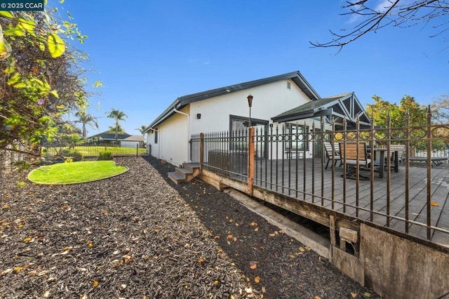 view of side of home with a wooden deck