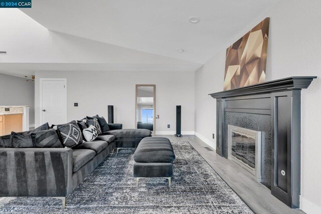 living room featuring vaulted ceiling and hardwood / wood-style flooring