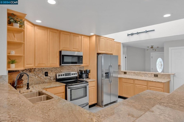 kitchen with stainless steel appliances, light brown cabinetry, and sink