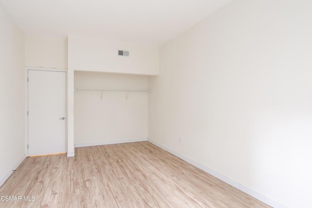 unfurnished bedroom with light wood-type flooring and a closet