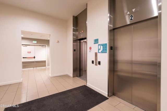 hall with light tile patterned flooring and elevator